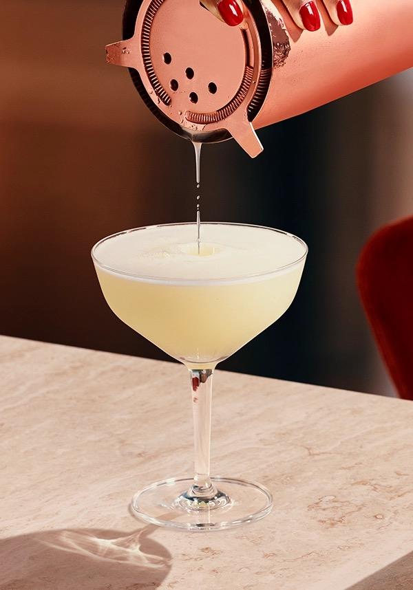 Ketel One Vodka Sour in Coupe Glass with hand pouring serve