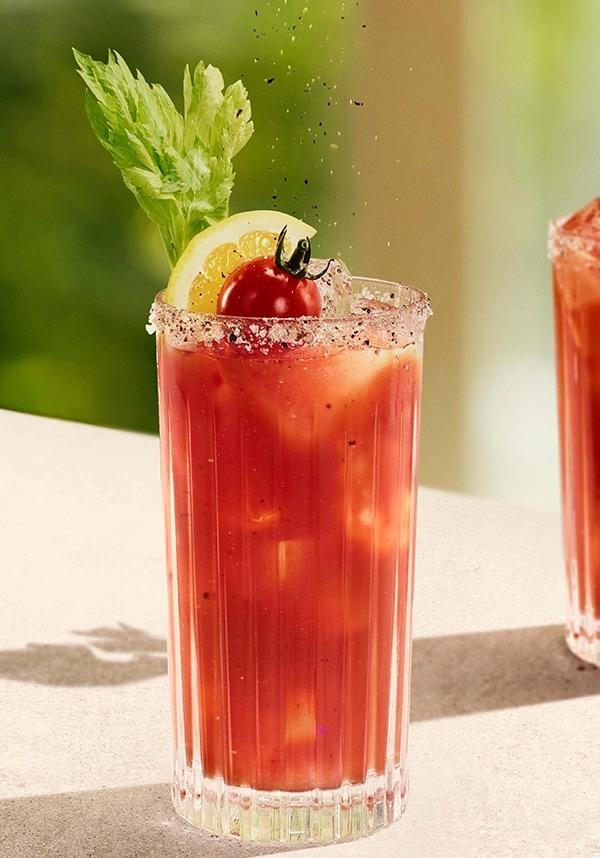 Ketel One Bloody Mary in High Ball Glass with hand grinding pepper 