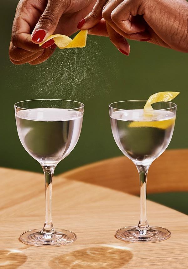 Ketel One Dry / Classic Martini in Nick and Nora Glass with hand adding lemon spritz