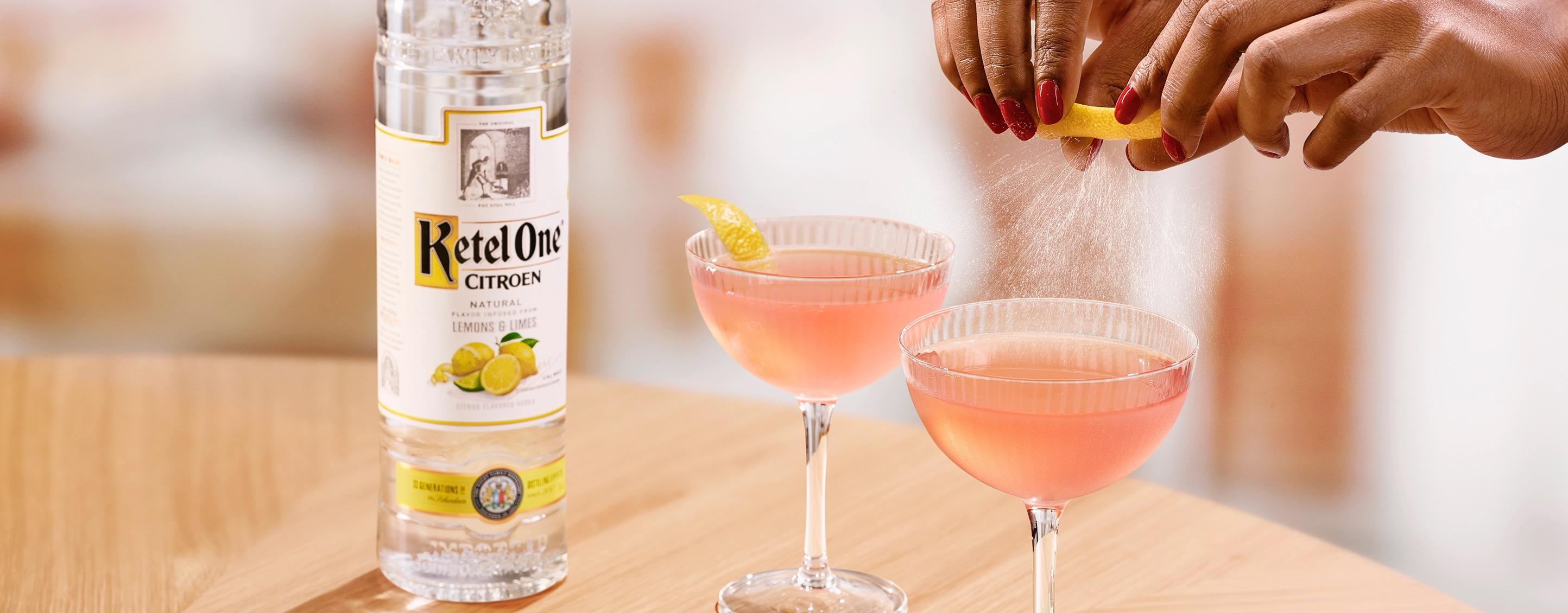 Ketel One Cosmo in Coupe Glass with hand adding lemon spritz