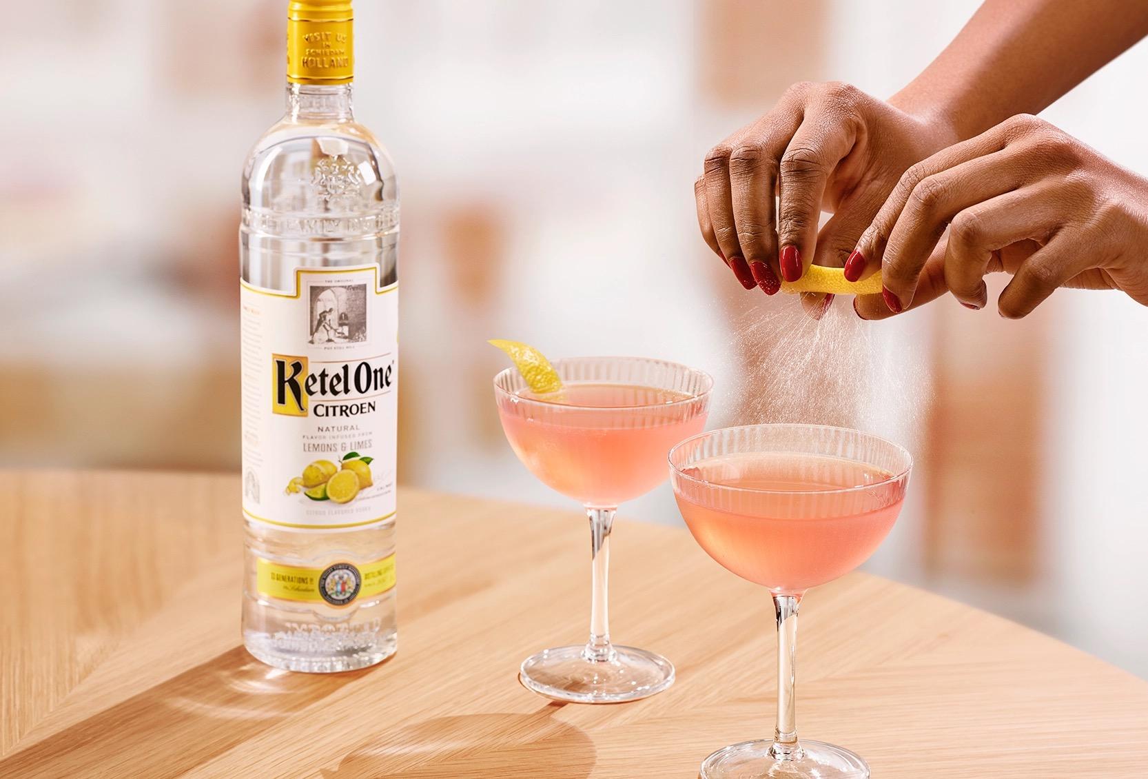 Ketel One Cosmo in Coupe Glass with hand adding lemon spritz