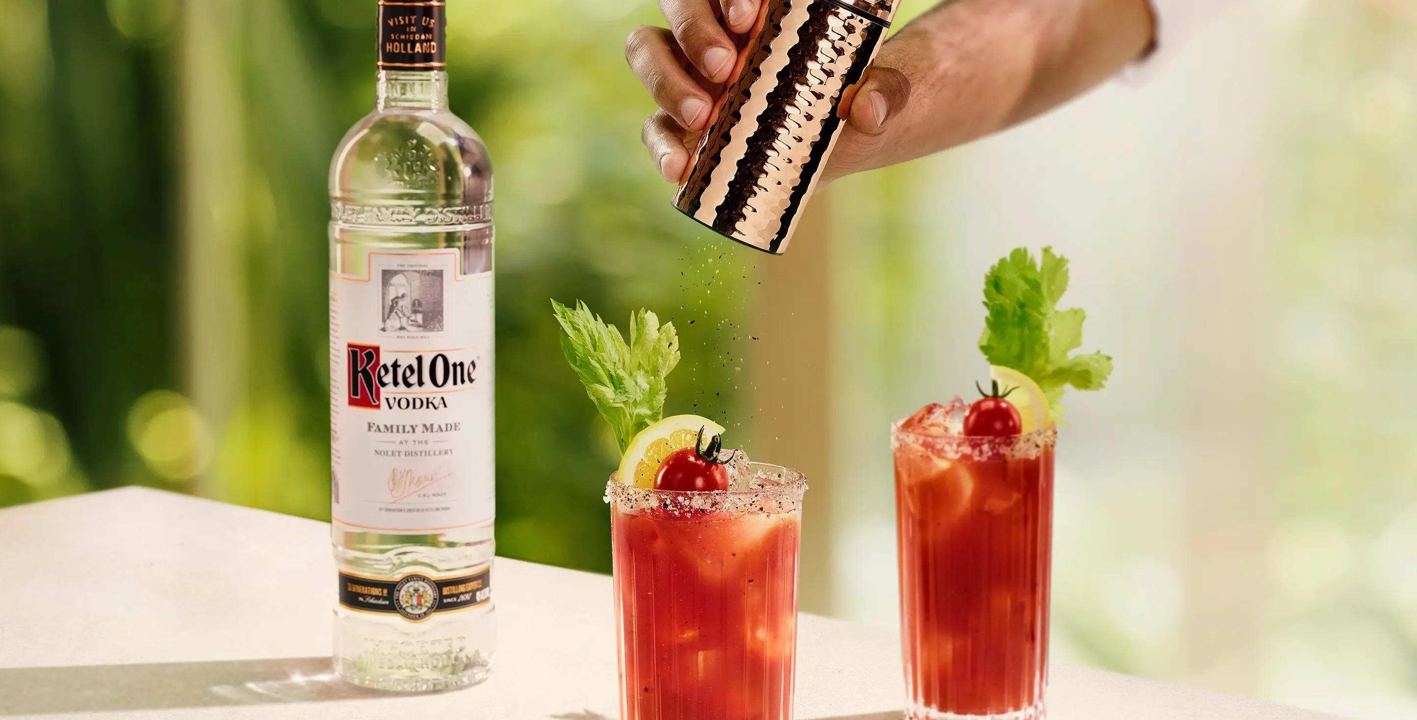 Ketel One Bloody Mary in High Ball Glass with hand grinding pepper 