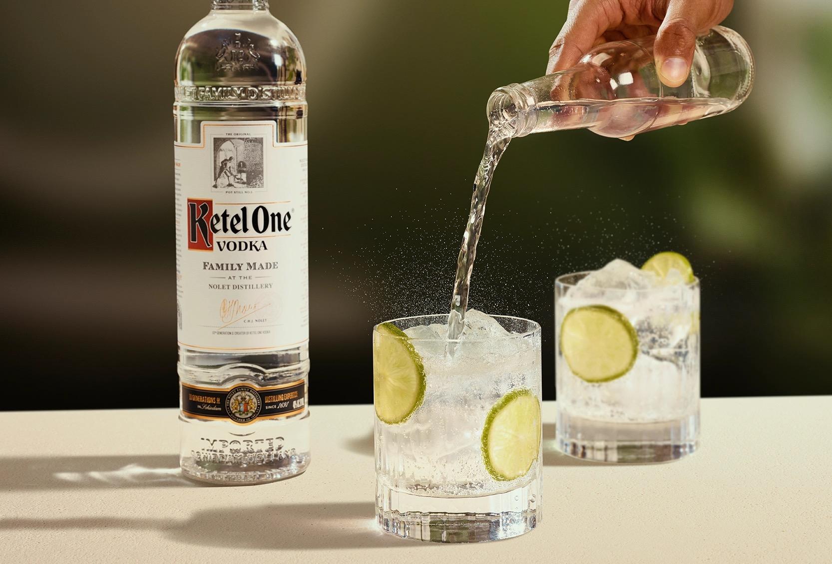 Ketel One Vodka Tonic in Rocks Glass with hand adding tonic